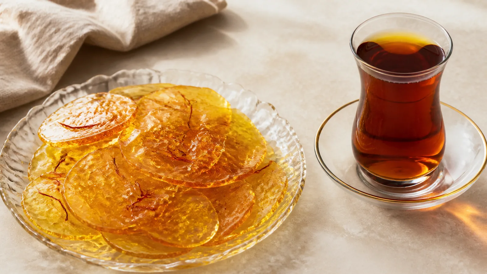 Thin golden saffron poolaki candy discs served with Persian tea